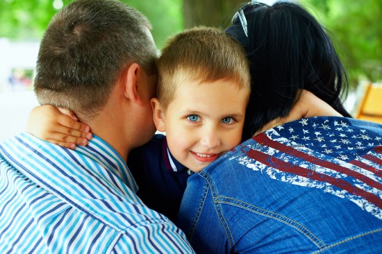 happy boy hugging parents